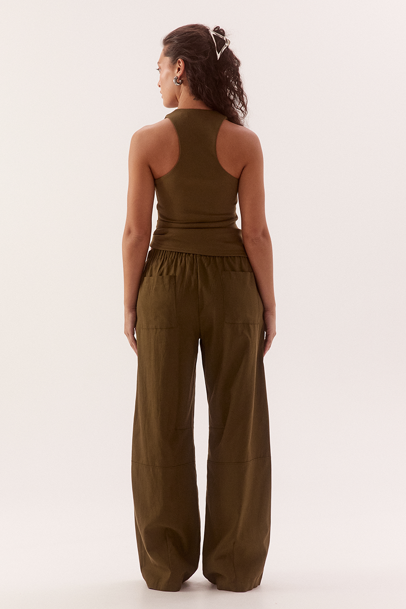 Women's viscose blend sleeveless top with deep scoop neckline, racer back, shoulder tucks, asymmetric hem and stretch lining.