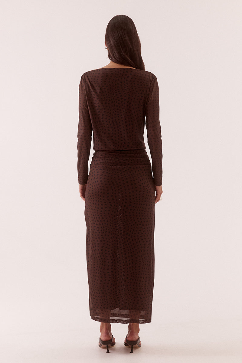 Model wearing an exclusive print long sleeve maxi dress with boat neckline, tucked shoulder and hip detailing, elastic waist, and side split skirt.