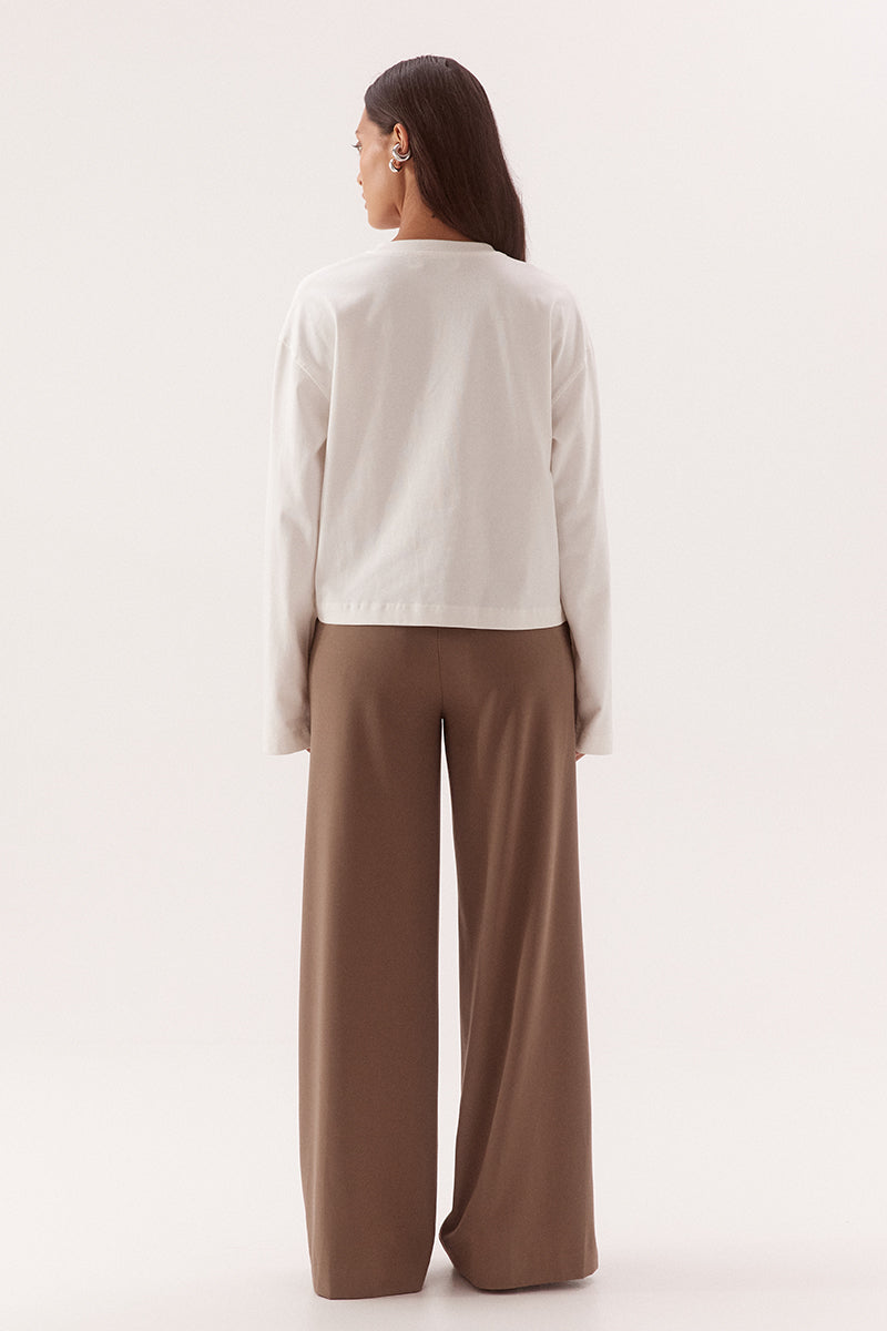 Women's oversized cotton long sleeve tee with dropped shoulders, crew neckline, and tucked front detail creating a flattering shaped hem.