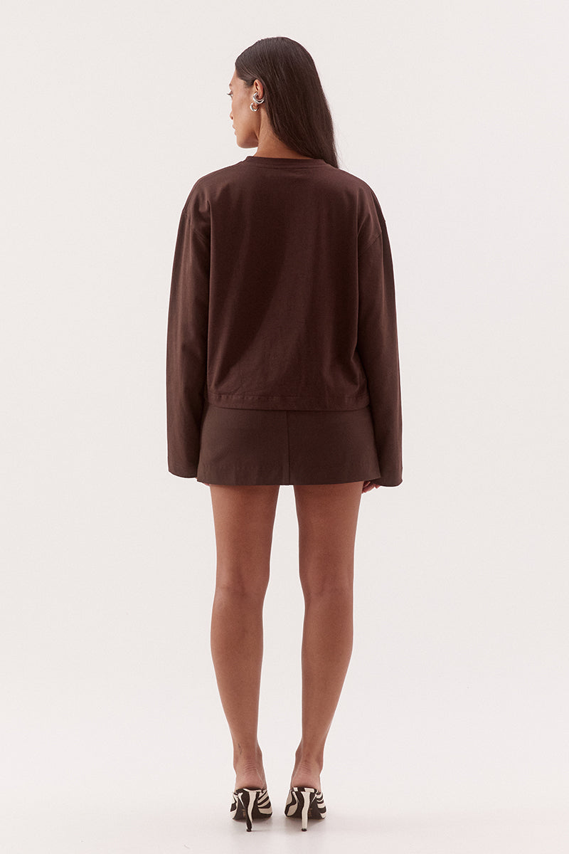Women's oversized cotton long sleeve tee with dropped shoulders, crew neckline, and tucked front detail creating a flattering shaped hem.