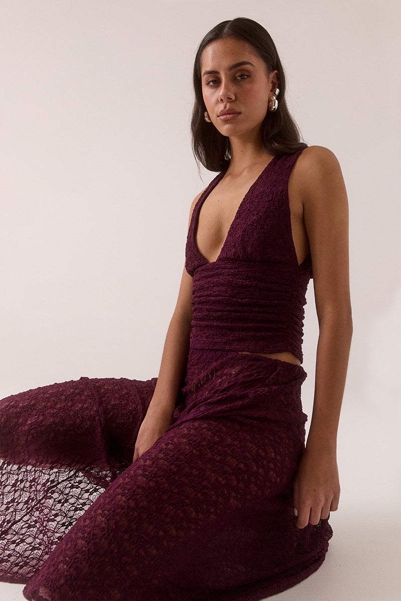 Fitted plunge neckline stretch lace top with empire line design, side gathers and pull-on fit, fully lined and worn by model in size 8.