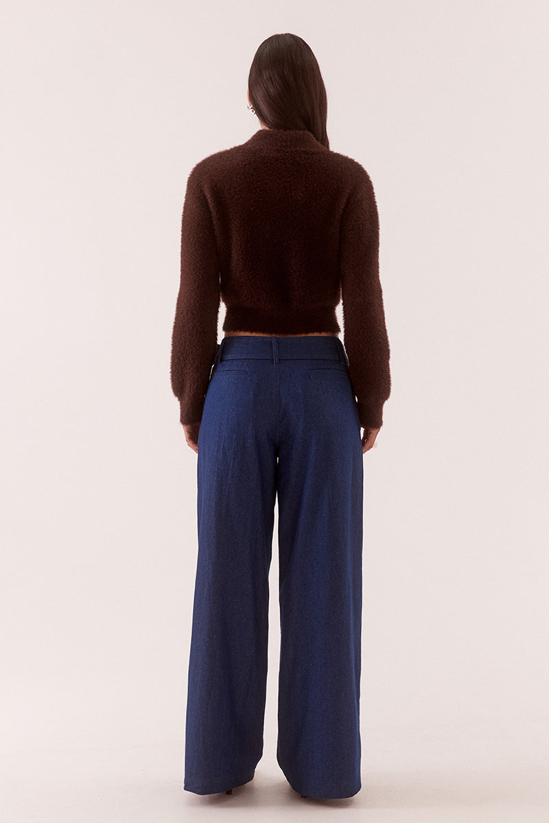 Model wearing a fluffy knit cardigan with collar, short buttoned front, long sleeves, dropped shoulders and fitted ribbed hem and cuffs.