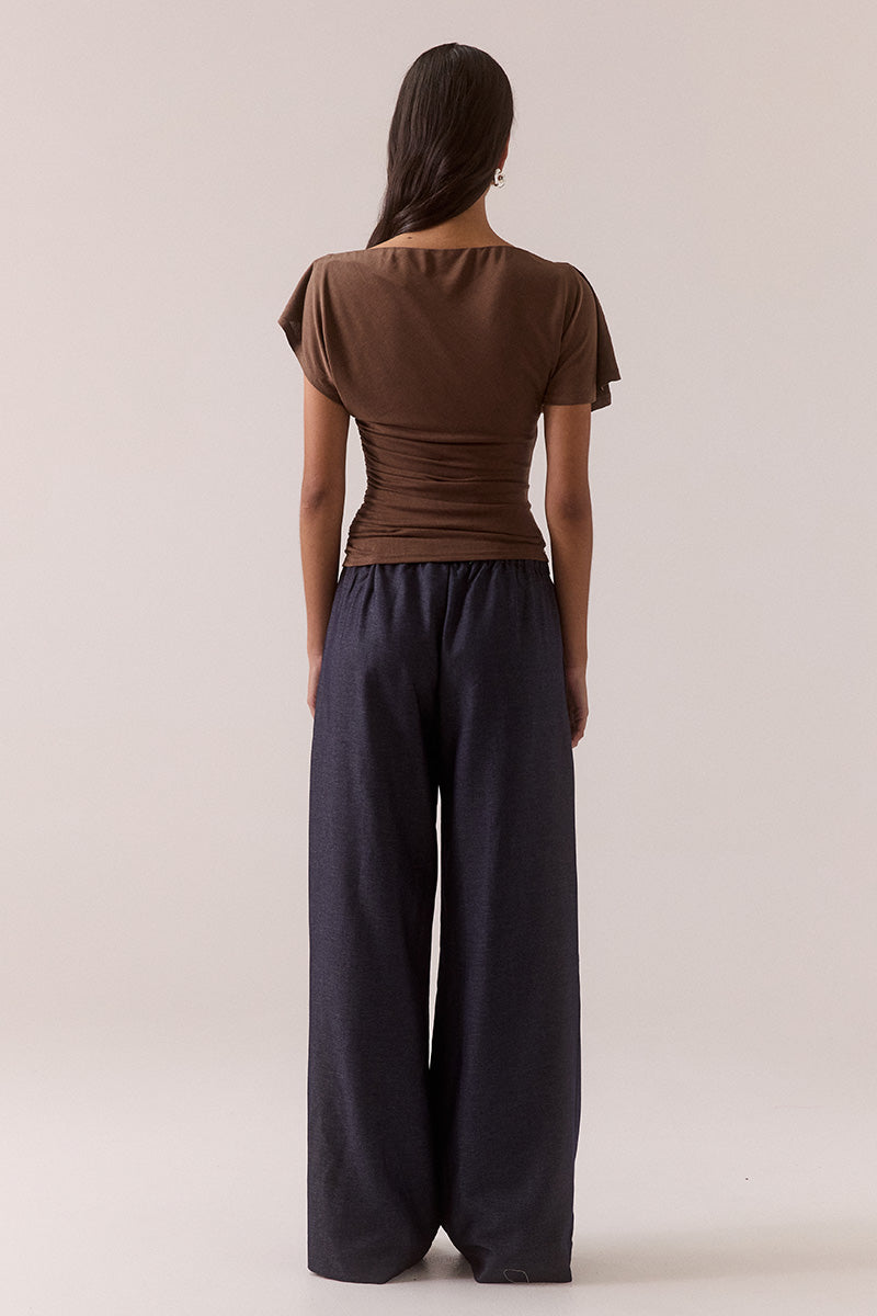 Model wearing slinky modal blend top with off-shoulder neckline option, asymmetric sleeve with split detail, gathered side seam, fully lined body-skimming fit.