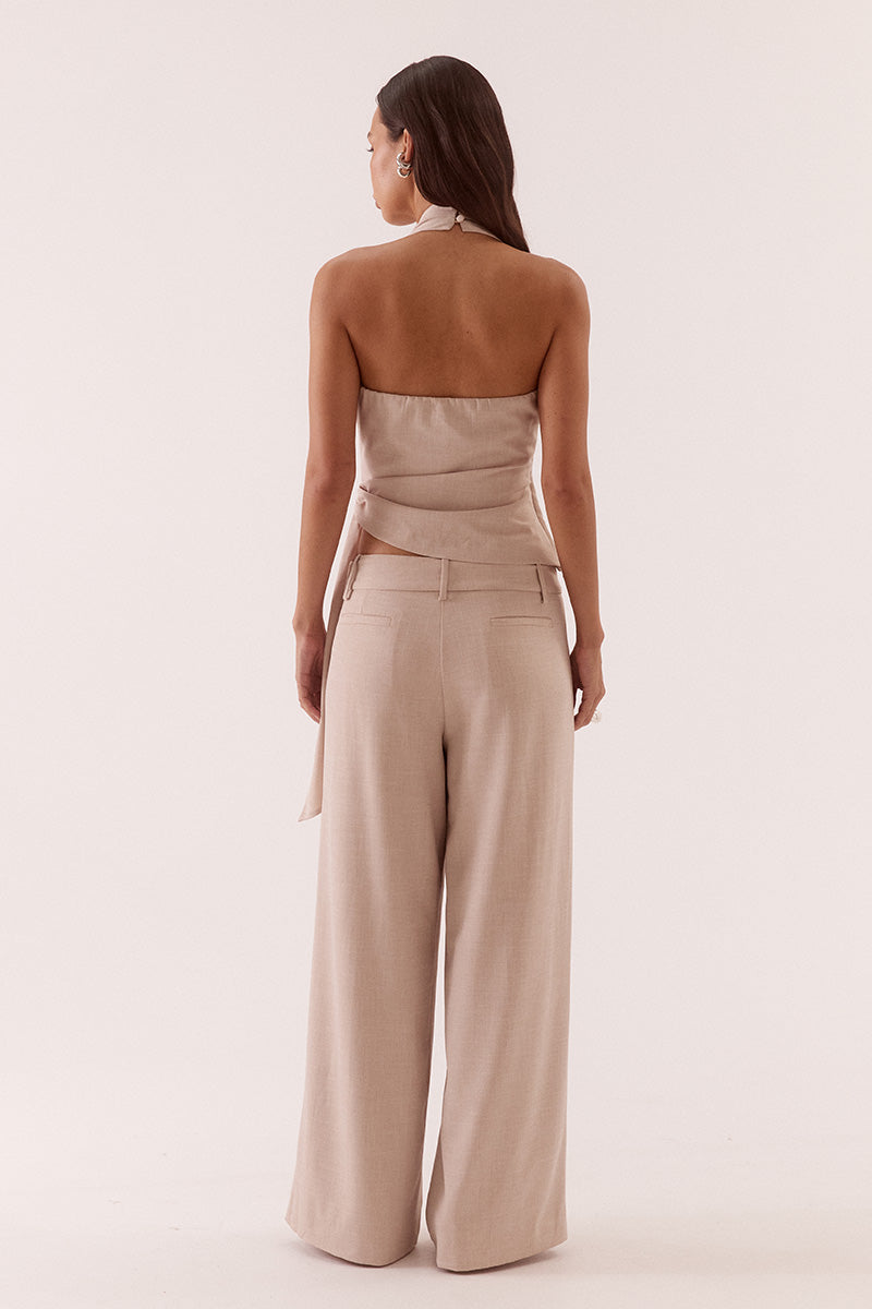 Women’s halter neck top in stretch rayon blend with wrap design, asymmetric hem, sash detail, elasticated back, and side zip closure.