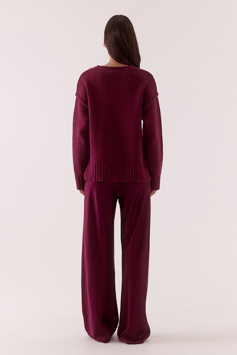 Women’s boxy knit sweater with plunging V-neckline, dropped shoulders, wide ribbed cuffs, and side split hem detail.