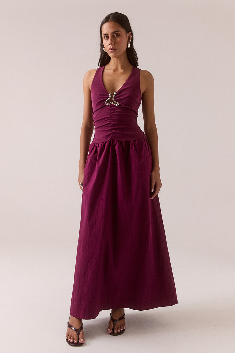 Sleeveless V-neck maxi dress in stretchy fabric with fitted bodice, full skirt, silver chest hardware, elasticated dropped waist and racer back, worn by model in size 8.