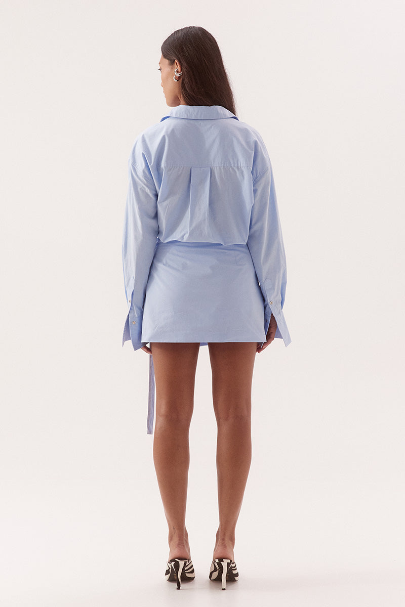 Women's cotton matching shirt and mini skirt set featuring relaxed fit shirt with chest pockets, and wrap-style A-line skirt with adjustable belt detail.