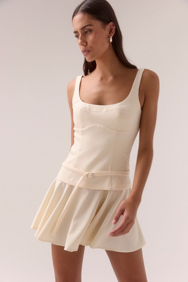 Woman wearing a white dress against a plain background